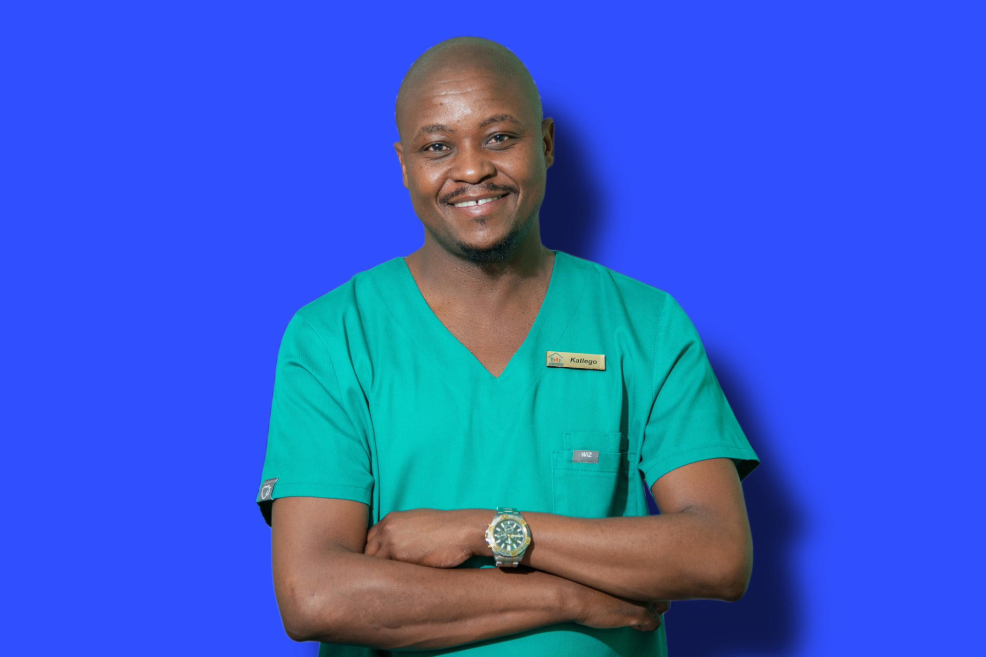 Katlego Aubeng, the doctor's secretary at Dr T Matseke Practice, smiling with arms crossed in teal scrubs